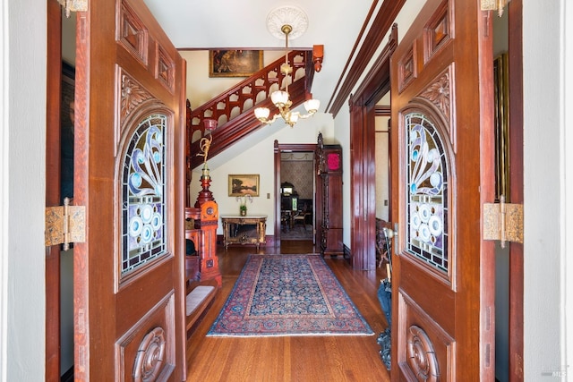 foyer with ornamental molding and dark hardwood / wood-style floors