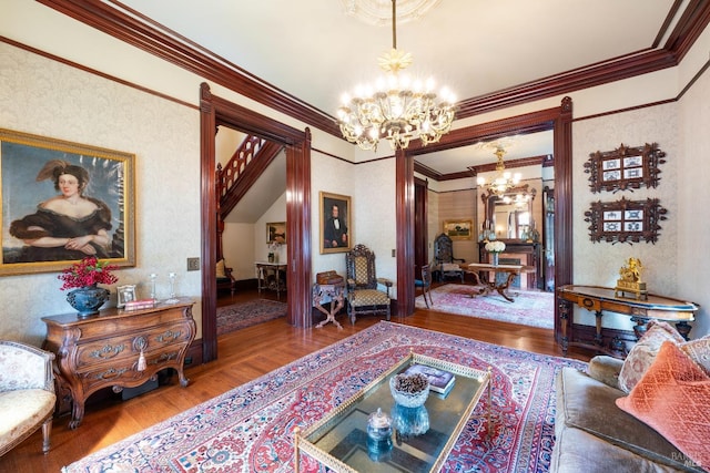 living room featuring an inviting chandelier, wood-type flooring, and crown molding