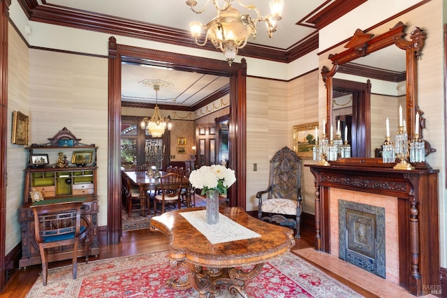 living room with crown molding, hardwood / wood-style floors, and a chandelier