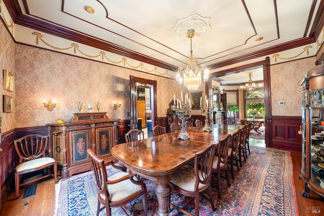 dining space featuring ornamental molding, hardwood / wood-style floors, and a chandelier