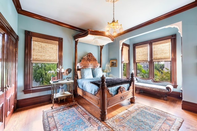 bedroom featuring a chandelier, light hardwood / wood-style floors, and multiple windows