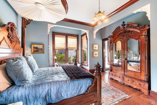 bedroom with hardwood / wood-style flooring, crown molding, and a chandelier