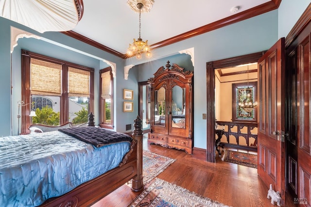 bedroom featuring ornamental molding, dark wood-type flooring, and a notable chandelier