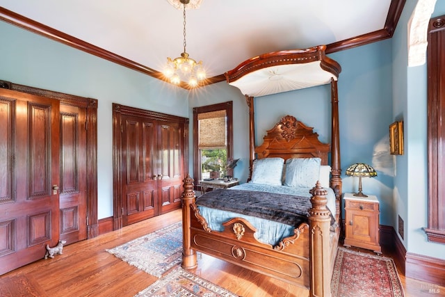 bedroom with crown molding, an inviting chandelier, and light hardwood / wood-style flooring