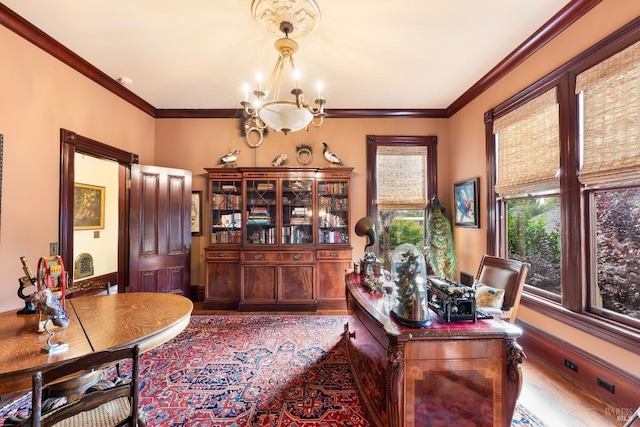 home office featuring wood-type flooring, ornamental molding, and a notable chandelier