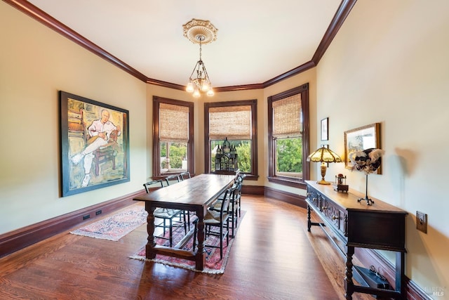 dining space with a notable chandelier, ornamental molding, and dark wood-type flooring