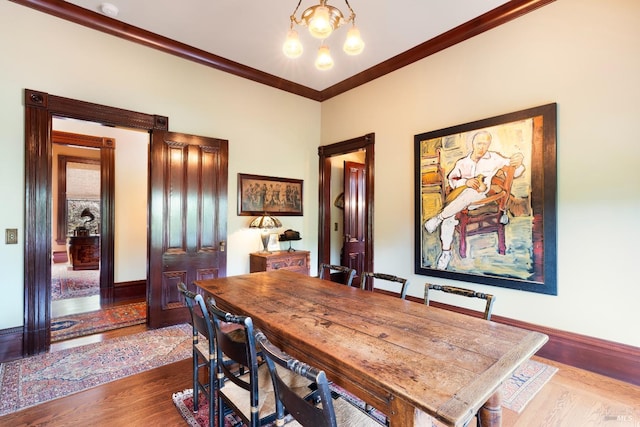 dining room featuring hardwood / wood-style flooring, a chandelier, and ornamental molding