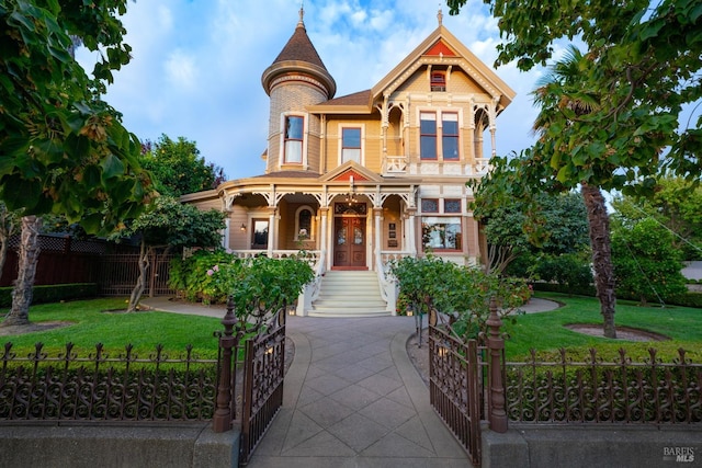 victorian house with a front lawn and a porch