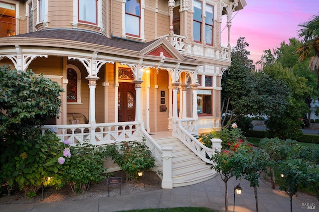 exterior entry at dusk featuring covered porch