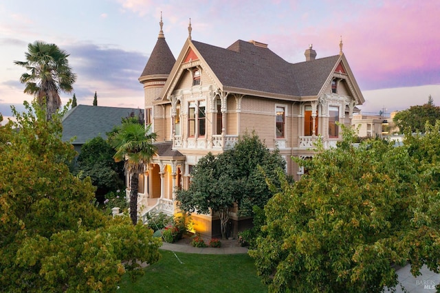 victorian house featuring a balcony and a porch