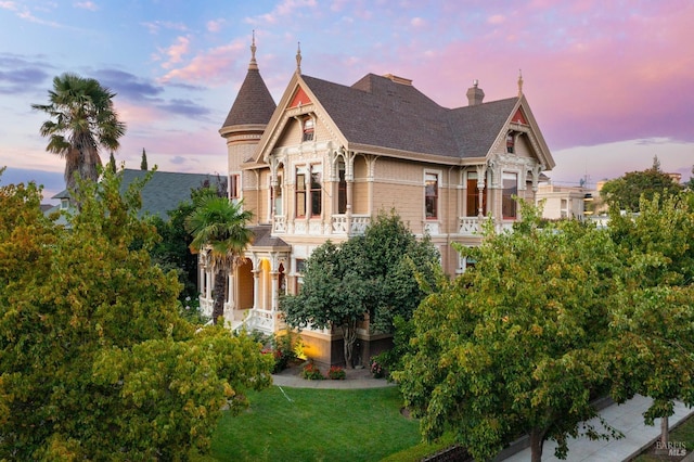 victorian house with a balcony and a lawn