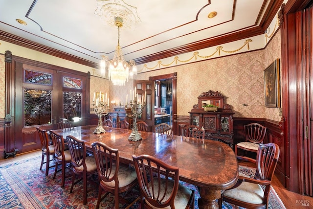 dining space with ornamental molding and a notable chandelier