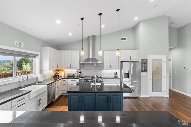 kitchen with stainless steel appliances, a sink, visible vents, white cabinets, and wall chimney exhaust hood