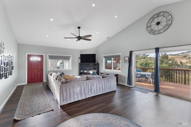 living area featuring high vaulted ceiling, dark wood-style flooring, a fireplace, and baseboards