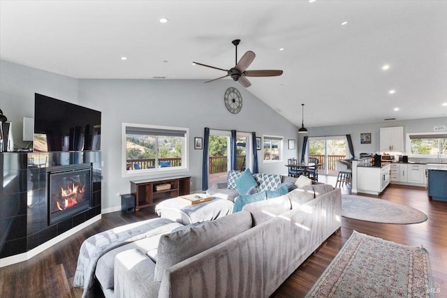 living room featuring a ceiling fan, a glass covered fireplace, dark wood finished floors, and recessed lighting