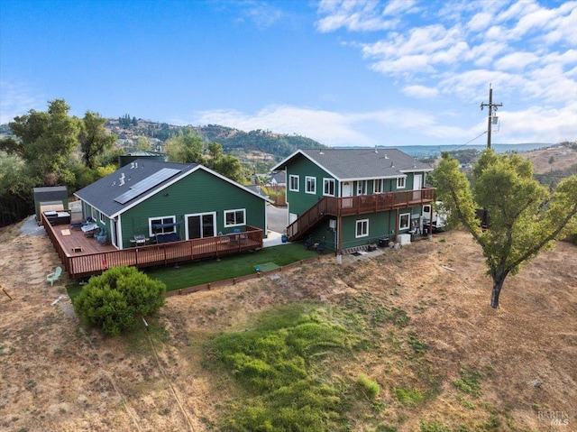 rear view of house featuring a yard and a deck