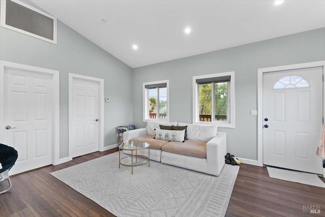 living area with dark wood-style floors, visible vents, vaulted ceiling, and baseboards