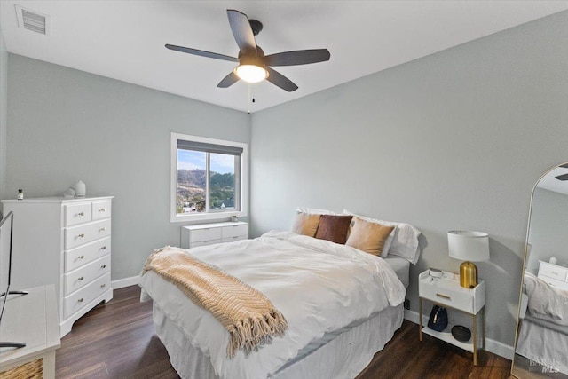 bedroom featuring baseboards, visible vents, ceiling fan, and wood finished floors