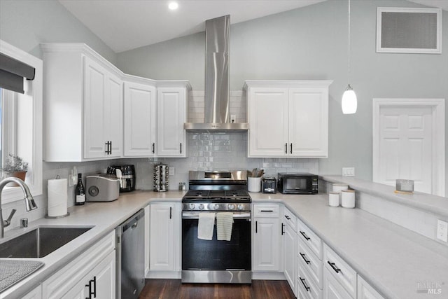 kitchen featuring stainless steel appliances, lofted ceiling, visible vents, white cabinets, and wall chimney range hood