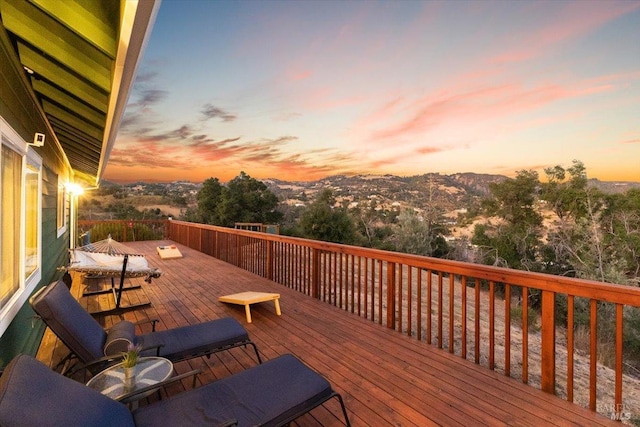 deck at dusk featuring a mountain view