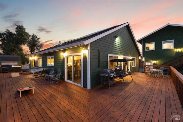 deck at dusk featuring outdoor dining area and grilling area