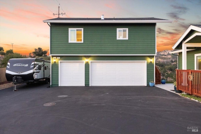 garage at dusk with aphalt driveway