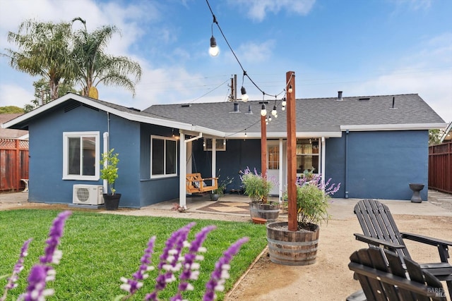 rear view of property with ac unit, a yard, and a patio