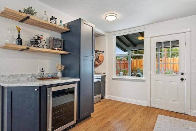 bar featuring light hardwood / wood-style flooring and beverage cooler