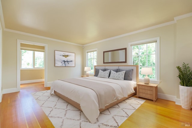 bedroom featuring multiple windows, crown molding, and light wood-type flooring