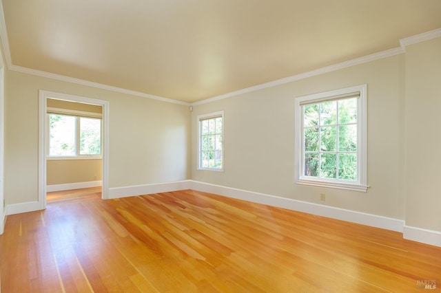 unfurnished room featuring hardwood / wood-style flooring, a healthy amount of sunlight, and crown molding