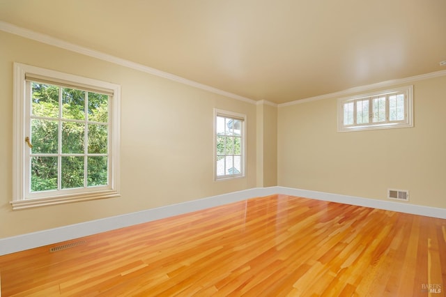 empty room with hardwood / wood-style flooring and crown molding