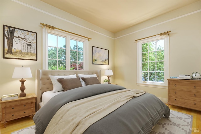 bedroom featuring crown molding and light wood-type flooring