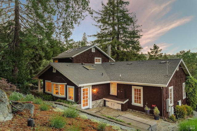 back house at dusk featuring a patio area