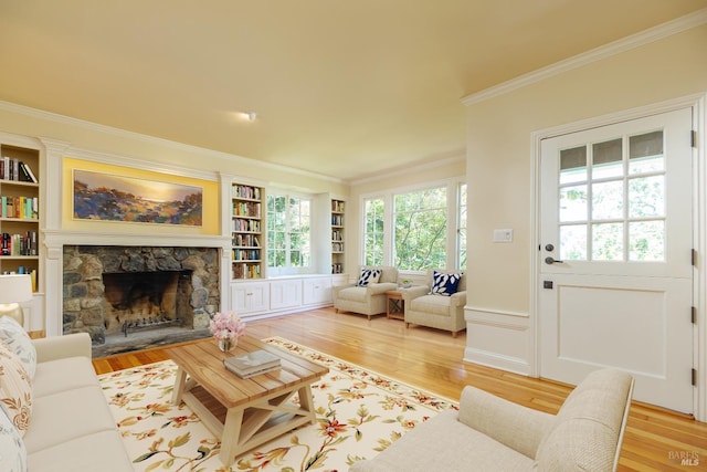 living room featuring crown molding, a fireplace, and light wood-type flooring