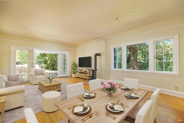 dining space with a wood stove and light hardwood / wood-style floors