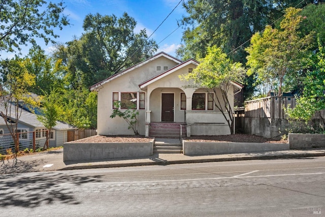 view of front of property featuring fence and stucco siding