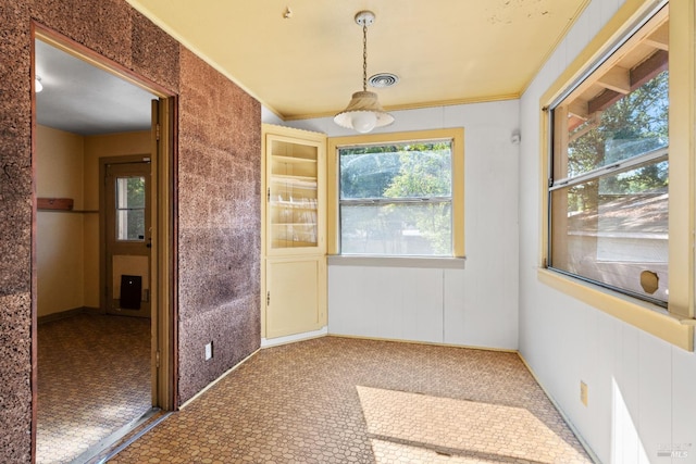 empty room with visible vents and crown molding