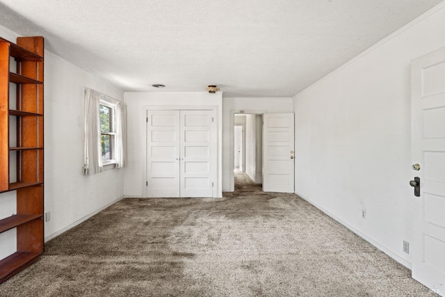 unfurnished bedroom featuring a textured ceiling, carpet floors, a closet, and baseboards