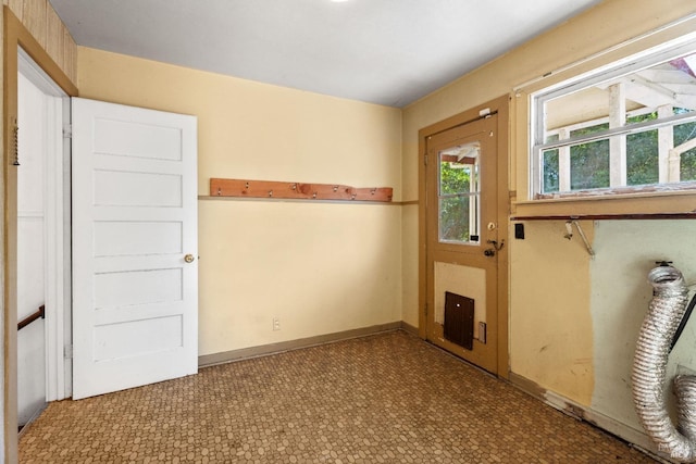 unfurnished room with baseboards and tile patterned floors