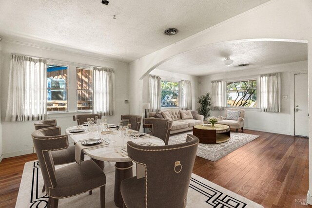 dining area with a textured ceiling and dark hardwood / wood-style flooring