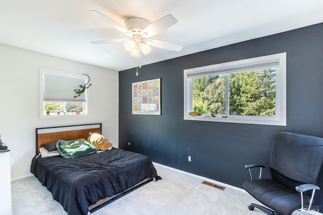 carpeted bedroom featuring ceiling fan and multiple windows