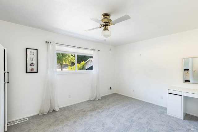 unfurnished room featuring light carpet and ceiling fan