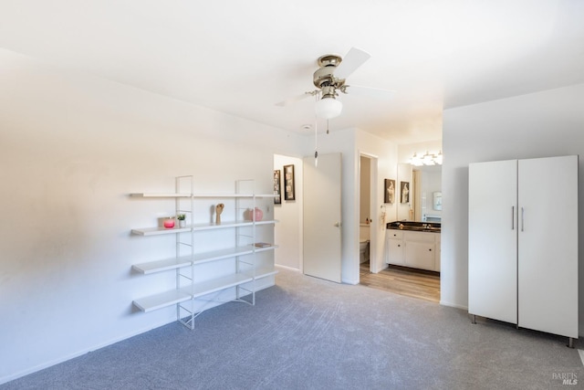 unfurnished bedroom with light carpet, ensuite bath, and ceiling fan