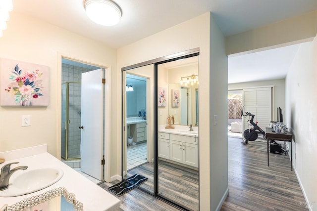 bathroom featuring a shower with door, vanity, and hardwood / wood-style floors