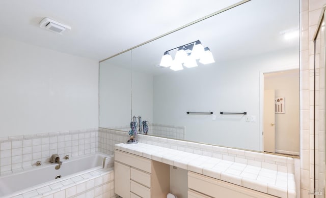 bathroom with vanity and tiled tub