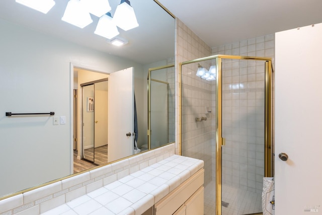 bathroom with wood-type flooring and an enclosed shower