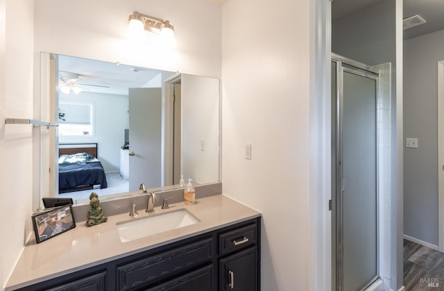 bathroom featuring vanity, hardwood / wood-style floors, walk in shower, and ceiling fan