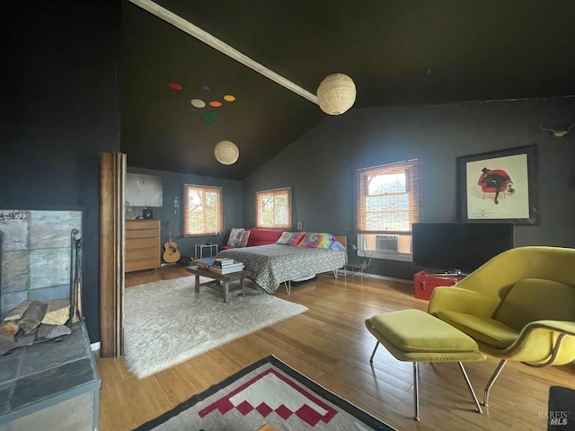 bedroom with vaulted ceiling, cooling unit, wood finished floors, and visible vents