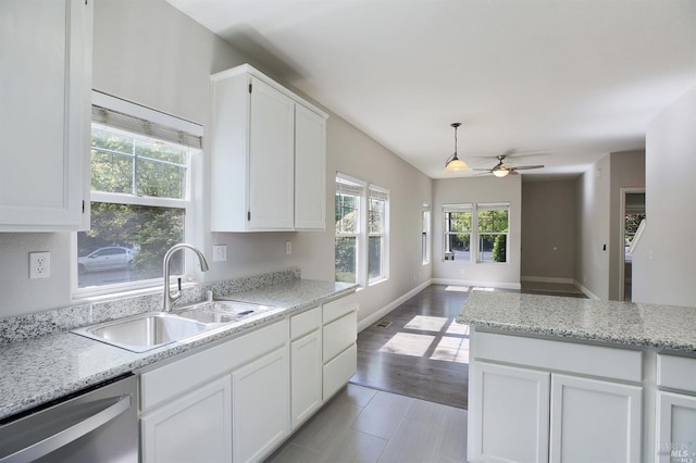 kitchen with white cabinets, sink, hanging light fixtures, light hardwood / wood-style flooring, and dishwasher