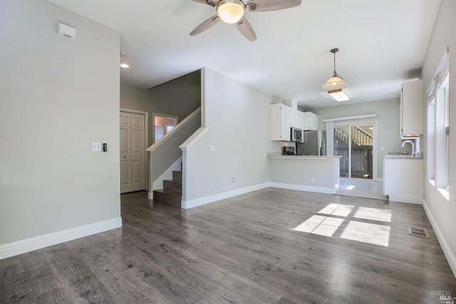 unfurnished living room with ceiling fan, dark hardwood / wood-style floors, and sink